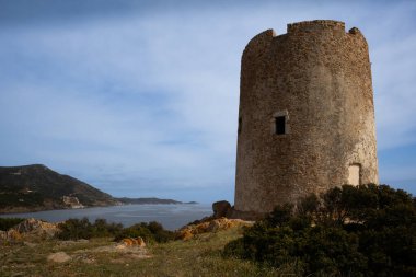 Sardinya 'nın güneyinde yer alan Torre di Pixinni adlı antik taş kulenin kalıntıları, Domus de Maria. Baharda bulutlu bir gün. Akdeniz adası Sardunya, İtalya.
