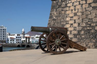 Aziz Gabriel Kalesi 'nden şehre taş köprü. Beyaz modern binalar ve Atlantik Okyanusu kıyısında bir kilise kulesi. Arrecife, Lanzarote, Kanarya Adaları, İspanya.