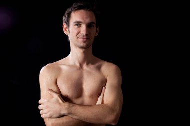 Gülümseyen üstsüz bir adam.