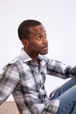 Yakışıklı siyah adam düşünceli görünüyor.