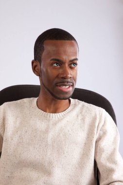 Yakışıklı siyah adam düşünceli görünüyor.