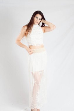 Beautiful woman in white outfit looking thoughtful 