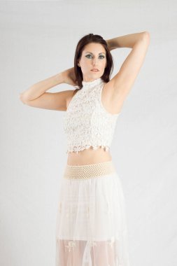 Beautiful woman in white outfit looking thoughtful 