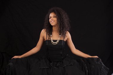 Gülümseyen siyah elbiseli güzel bir kadın.