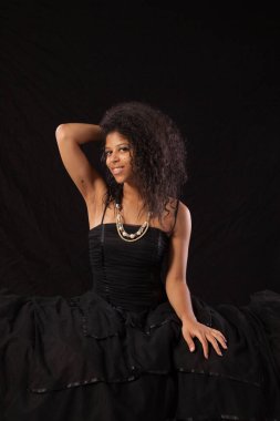 Gülümseyen siyah elbiseli güzel bir kadın.