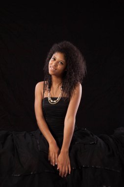 Gülümseyen siyah elbiseli güzel bir kadın.