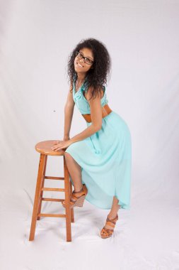 Elbise ve tahta tabure giymiş mutlu bir kadın.