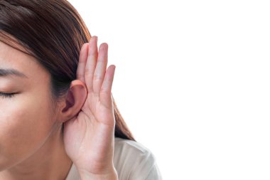 Asyalı kadın beyaz tişört giyer işitme kaybı ya da işitme zorluğu çeker ve elini kulağının arkasına sokar. Beyaz arka planda izole edilmiş, sağır konsepti..