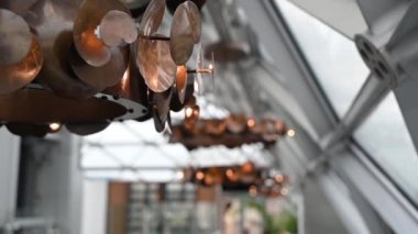 Metal yapıların modern stil tasarımının arka planında bakır renkli metal avize var. Kamerası yavaş hareket eden metal bir avizeye yakın plan..