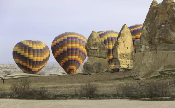 Hot Air balloon behind rocks in the desert — Stock Photo, Image