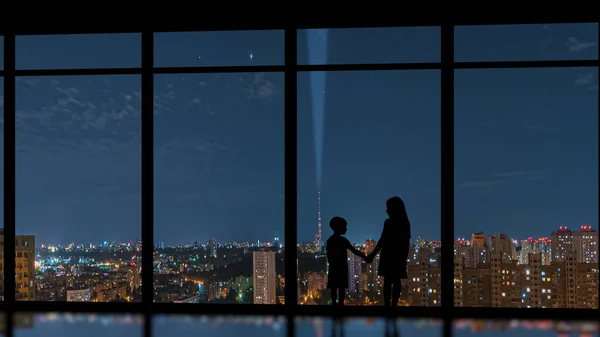 男孩和女孩站在城市背景上的全景窗前 — 图库照片