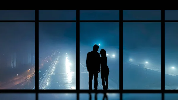Mannen Och Kvinnan Står Nära Panoramafönstret Mot Nattstaden — Stockfoto