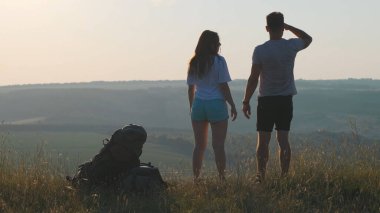 The couple of travelers standing on the mountain top