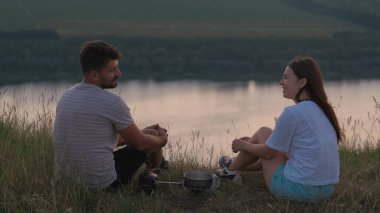 The romantic couple sitting on mountain top and drinking tea