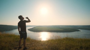 The man drinking water on a beautiful river background