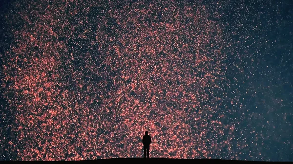 The human silhouette stands on a shiny particles background