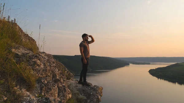 Young Man Stands Rocky Mountain Beautiful River Background — kuvapankkivalokuva