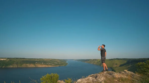 Man Drinking Water Beautiful River Background — Stok Foto