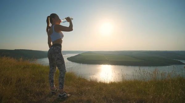 Sportive Woman Drinking Water Beautiful River Background — kuvapankkivalokuva