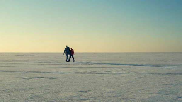 Two People Walking Endless Snow Field — kuvapankkivalokuva