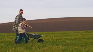 The dad with his little son are going to plant a tree