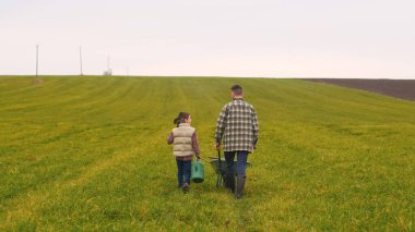 The father and son walking through the green field