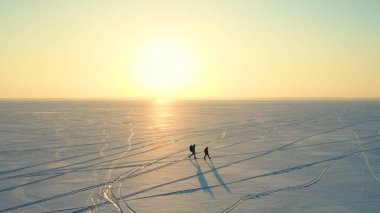 The beautiful view on the snow field and walking expeditors