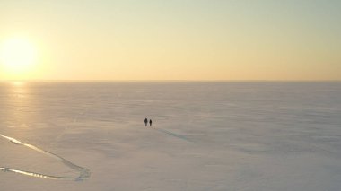 The two explorers going trough the snow field