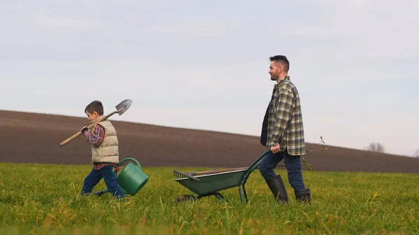 Father Son Walking Field Wheelbarrow – stockfoto