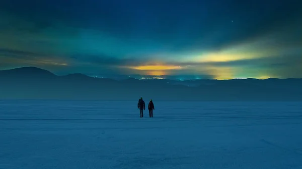 Two Tourists Walking Snow Field Starry Sky Background – stockfoto