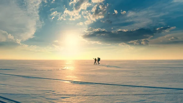Couple Travelers Walking Snow Field Sunset Background – stockfoto