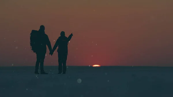 Two Travelers Standing Snow Field Beautiful Sunset — kuvapankkivalokuva