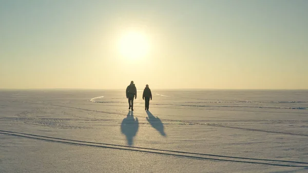 Couple Travelers Walking Snow Field Sunset Background – stockfoto