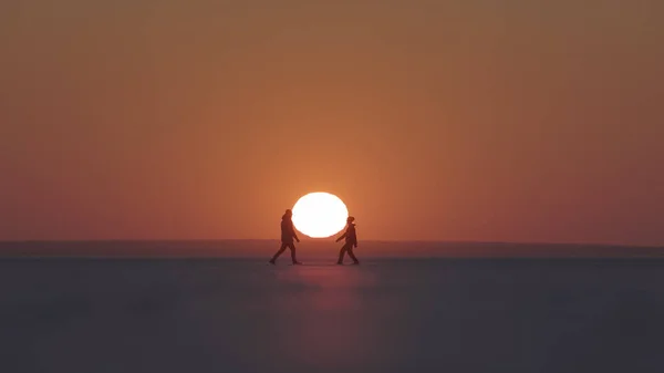 Couple Travelers Walking Snow Field Sunset Background — Stockfoto