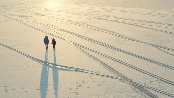 Aerial View Two Travelers Walking Snow Field – stockfoto