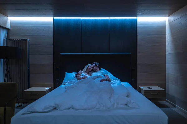 ชายและผ งนอนบนเต ยงในห องพ กโรงแรม — ภาพถ่ายสต็อก