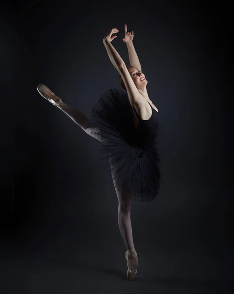 Aantrekkelijke Ballerina Staat Haar Vingertoppen Fotoshoot Studio Een Donkere Achtergrond — Stockfoto