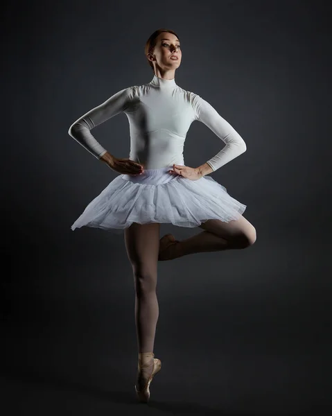 Aantrekkelijke Ballerina Staat Haar Vingertoppen Fotoshoot Studio Een Donkere Achtergrond — Stockfoto