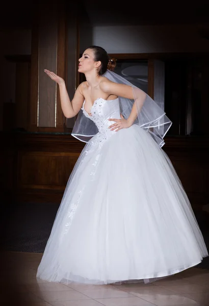 Full length portrait of beautiful bride giving a kiss. — Stock Photo, Image