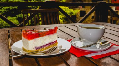 Masada çilekli kek ve bir fincan çay var.