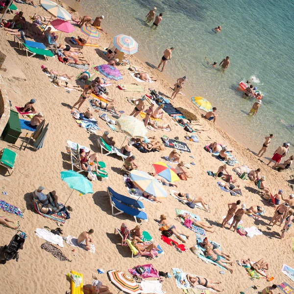 People and sun umbrellas on the beach — Stock Photo, Image