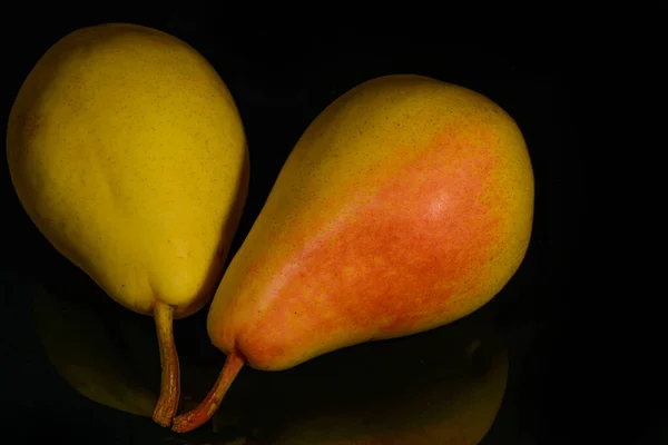 Reife gelbe Birnenfrucht, mit Reflexion in schwarzer Oberfläche, isoliert auf schwarz — Stockfoto