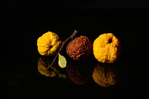 Nagyon szárított gyümölcs sárga birsalma, tükröződve a fekete felületen — Stock Fotó