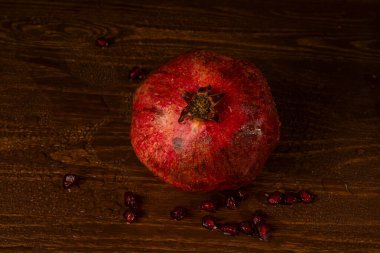 Masanın üzerinde olgun kırmızı bir nar var. Yakın plan.
