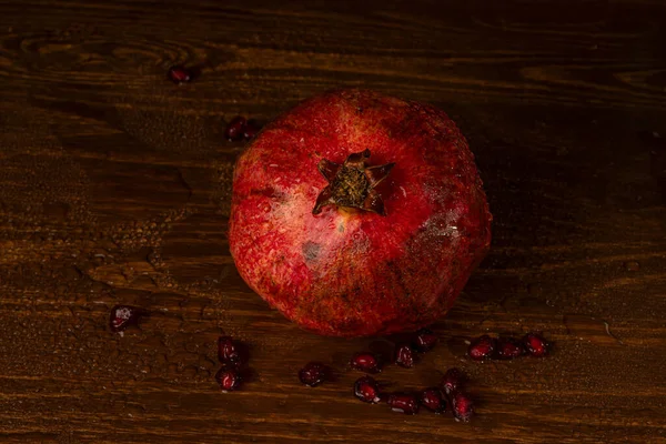 Granada húmeda madura roja sobre la mesa. Primer plano —  Fotos de Stock