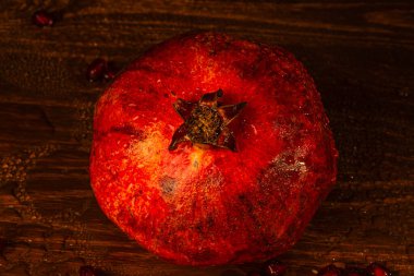 Masanın üzerinde olgun kırmızı bir nar var. Yakın plan.