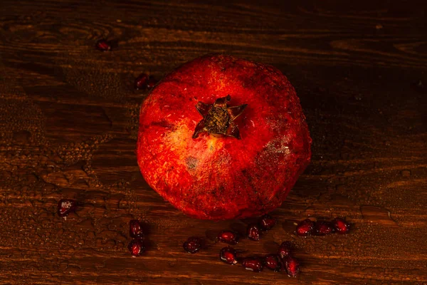 Romã molhada madura vermelha sobre a mesa. Close-up — Fotografia de Stock