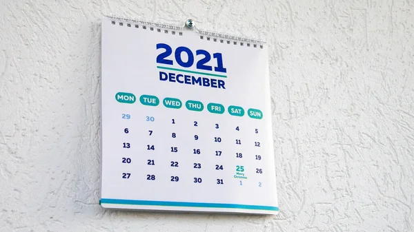 Bir duvar takvimi 2021 'in Aralık sayfasındaki yakın plan. Üzerinde yılbaşı tarihi yazıyor.