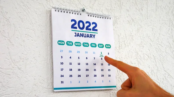 2022 yılının Ocak ayı takvimi ve yeni yılın ilk gününü gösteren bir adam.