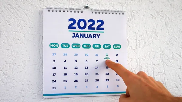 2022 yılının Ocak ayı takvimi ve yeni yılın ilk gününü gösteren bir adam.